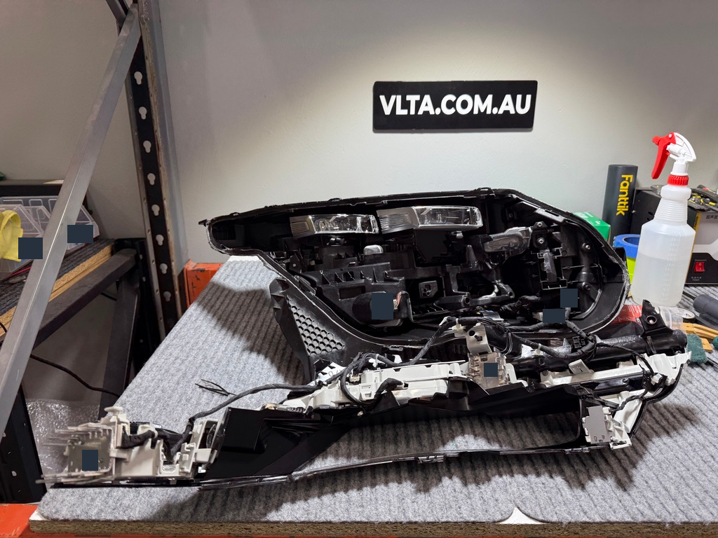 The opened headlight, with the housing and internal components separated.
